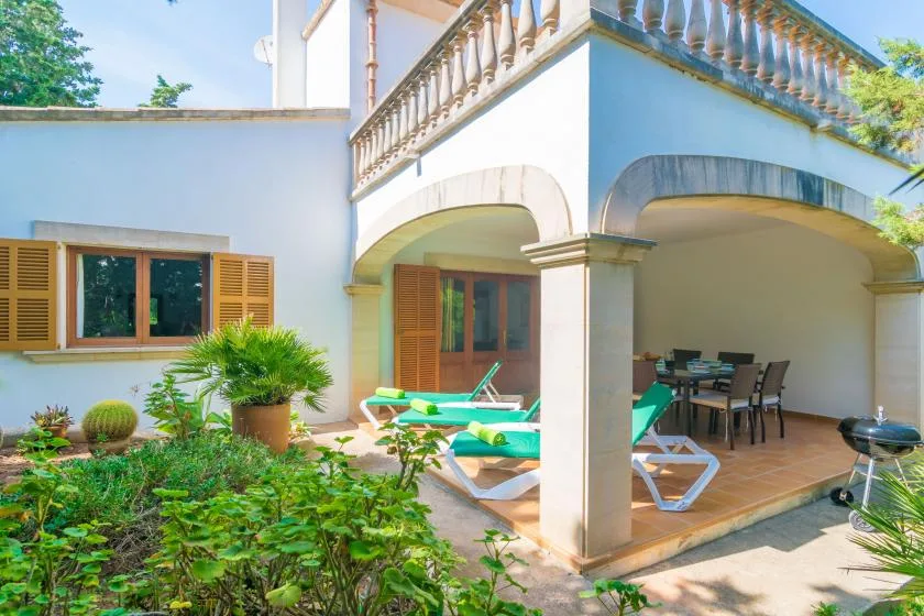 Un patio interior con una pequeña piscina, asientos de descanso y un comedor cubierto.