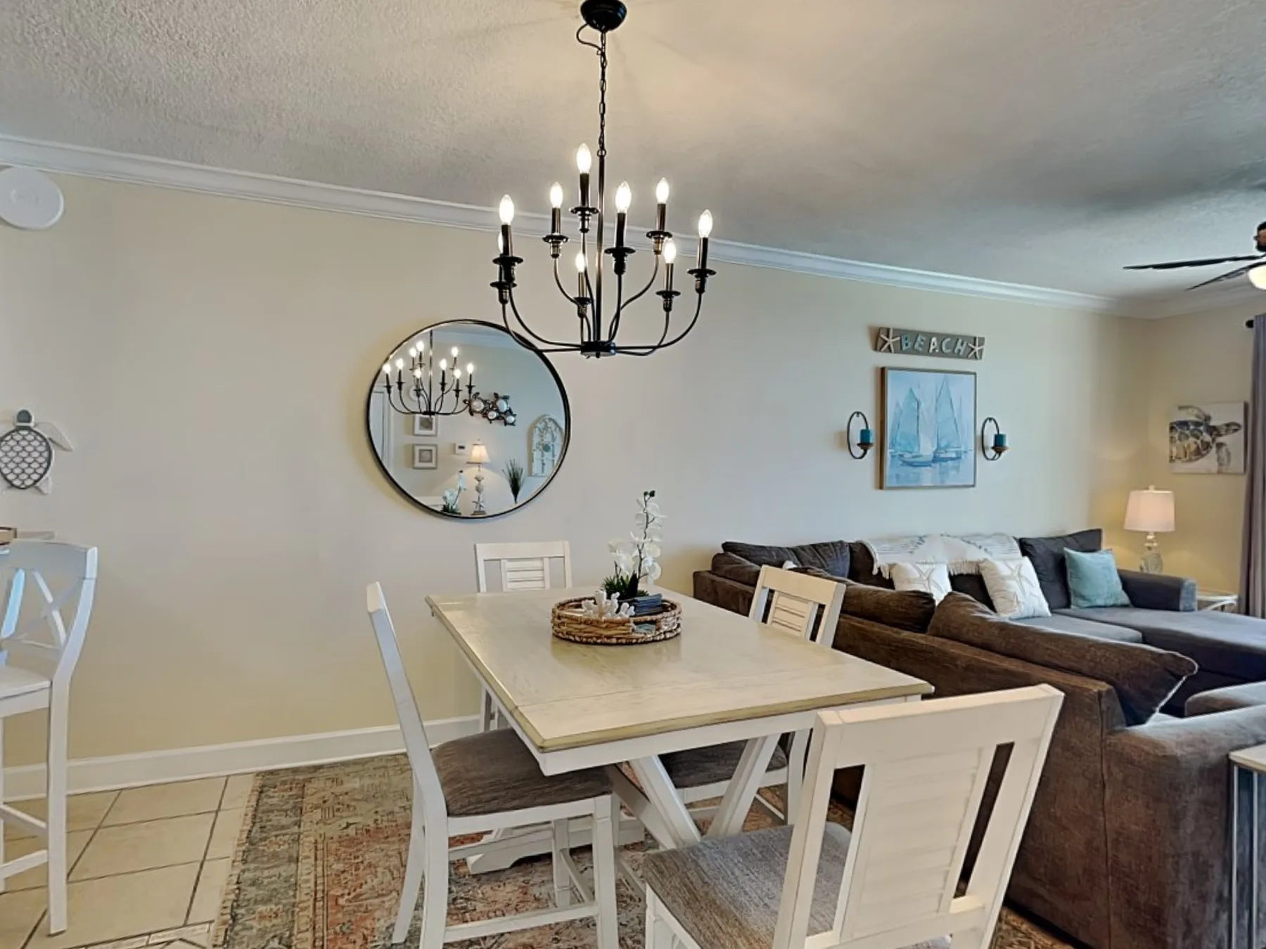 A dining area opens onto a living room with a large sectional seating area.