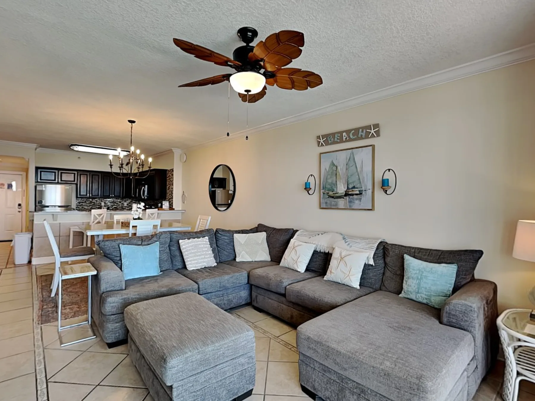 A living room with sectional seating and an open kitchen and dining area.