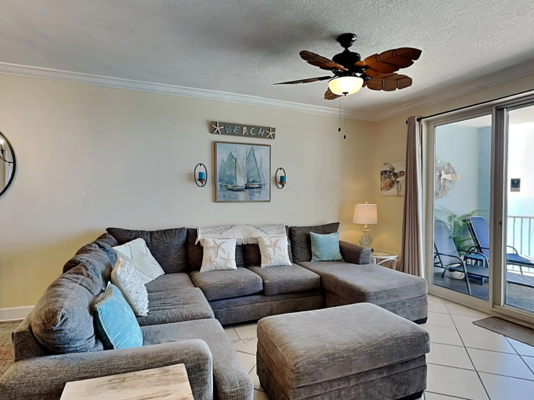 A living room with a sectional seating area and sliding glass doors.