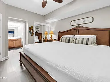 Un dormitorio con una cama grande y una puerta que da a un baño.