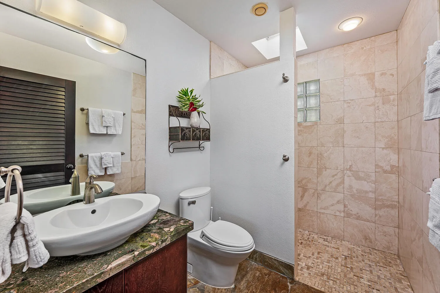 Un baño con lavabo, inodoro y zona de ducha con azulejos.