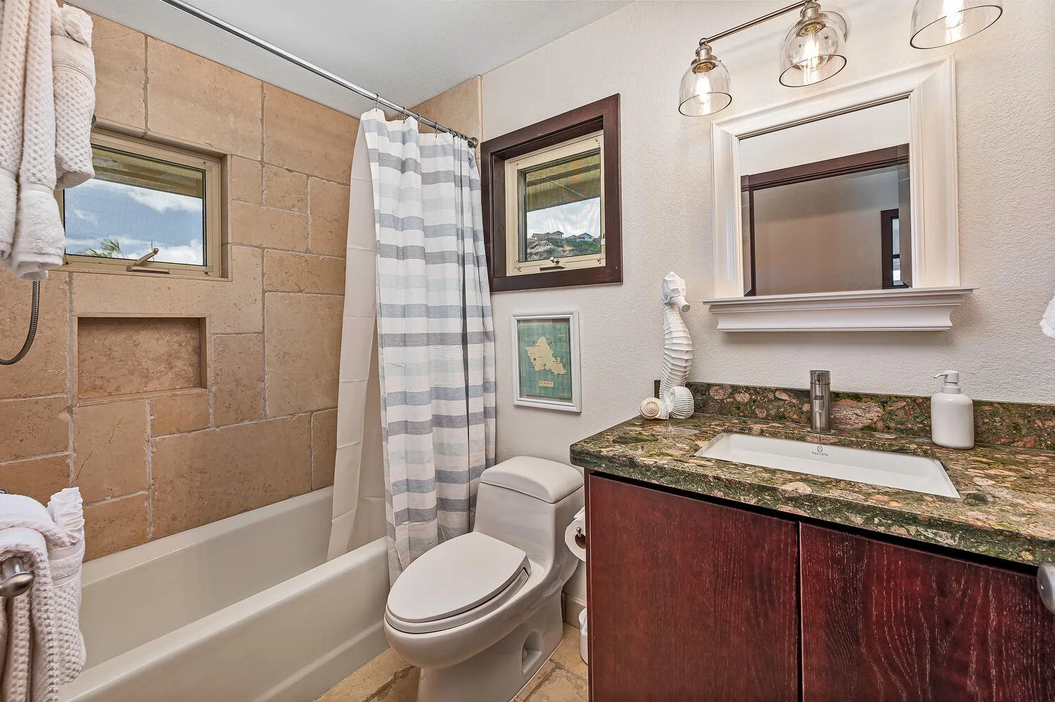 Un baño con bañera, cortina de ducha, inodoro y tocador.