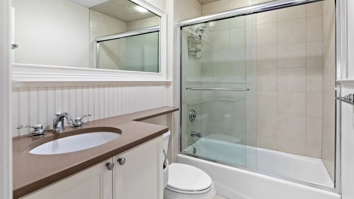 Un baño con lavabo, espejo y ducha de vidrio.