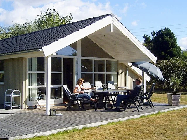 A modern house with a covered patio and outdoor seating.