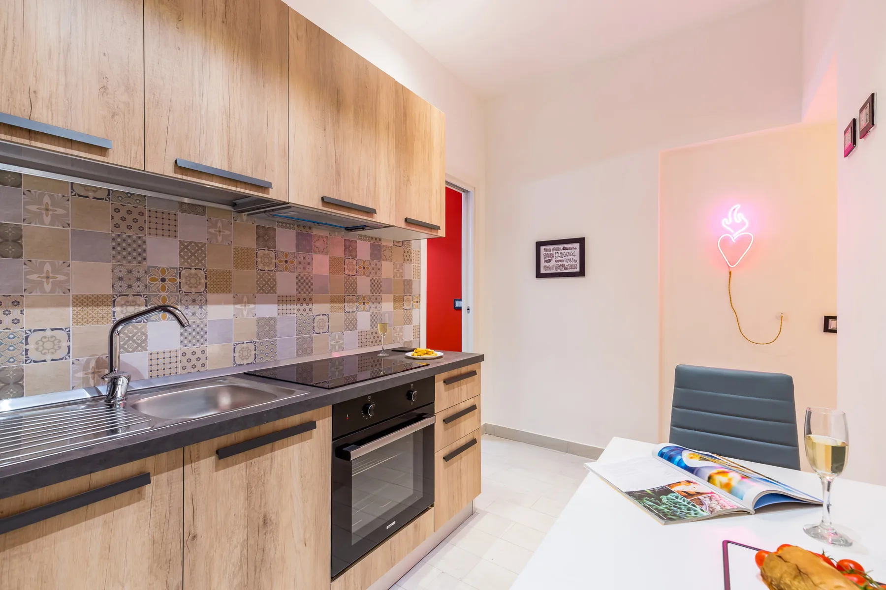 A compact kitchen with wood cabinets and a counter opening onto a small dining area.