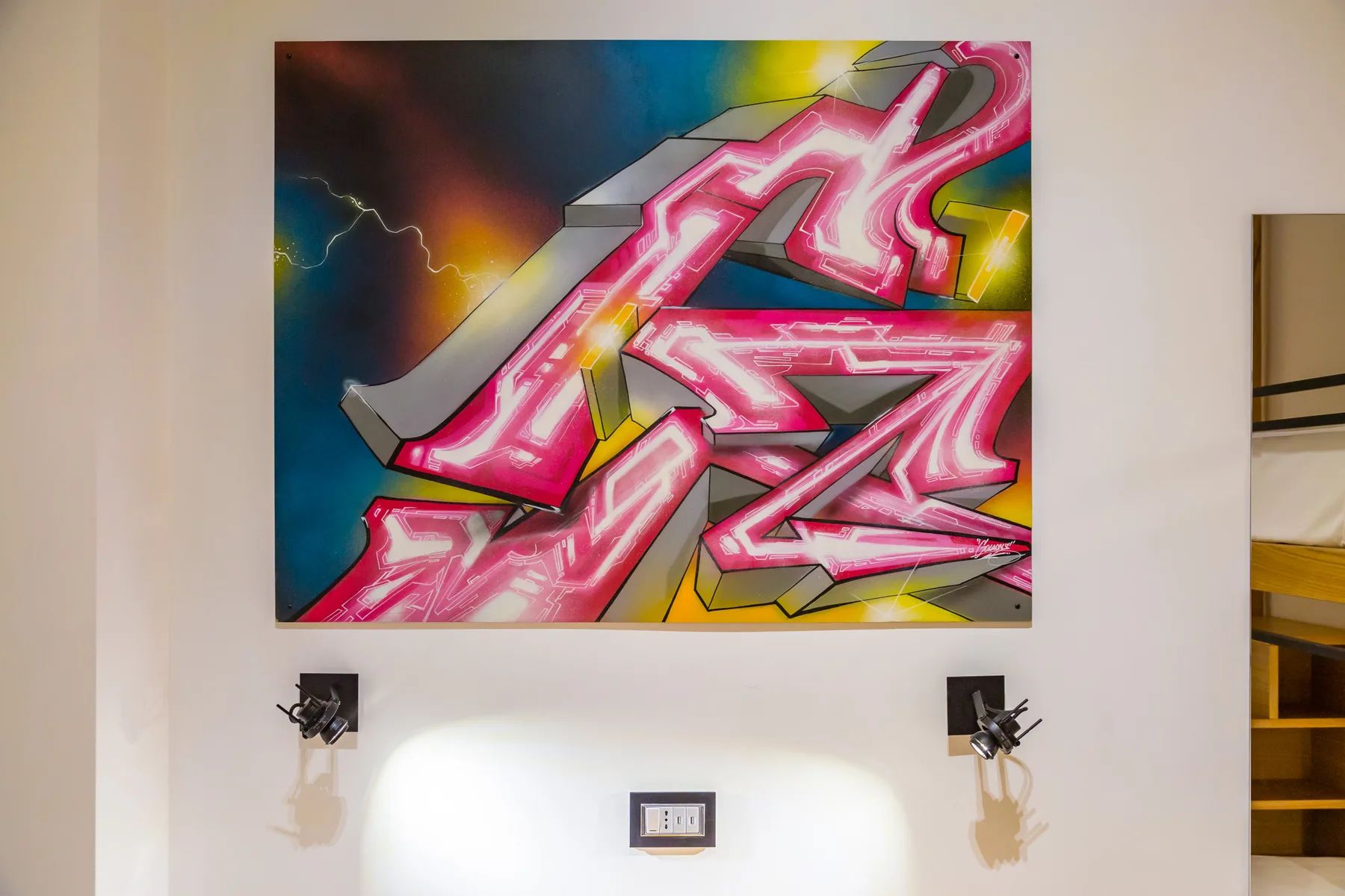 Una obra colorida de estilo grafiti cuelga en una pared clara.