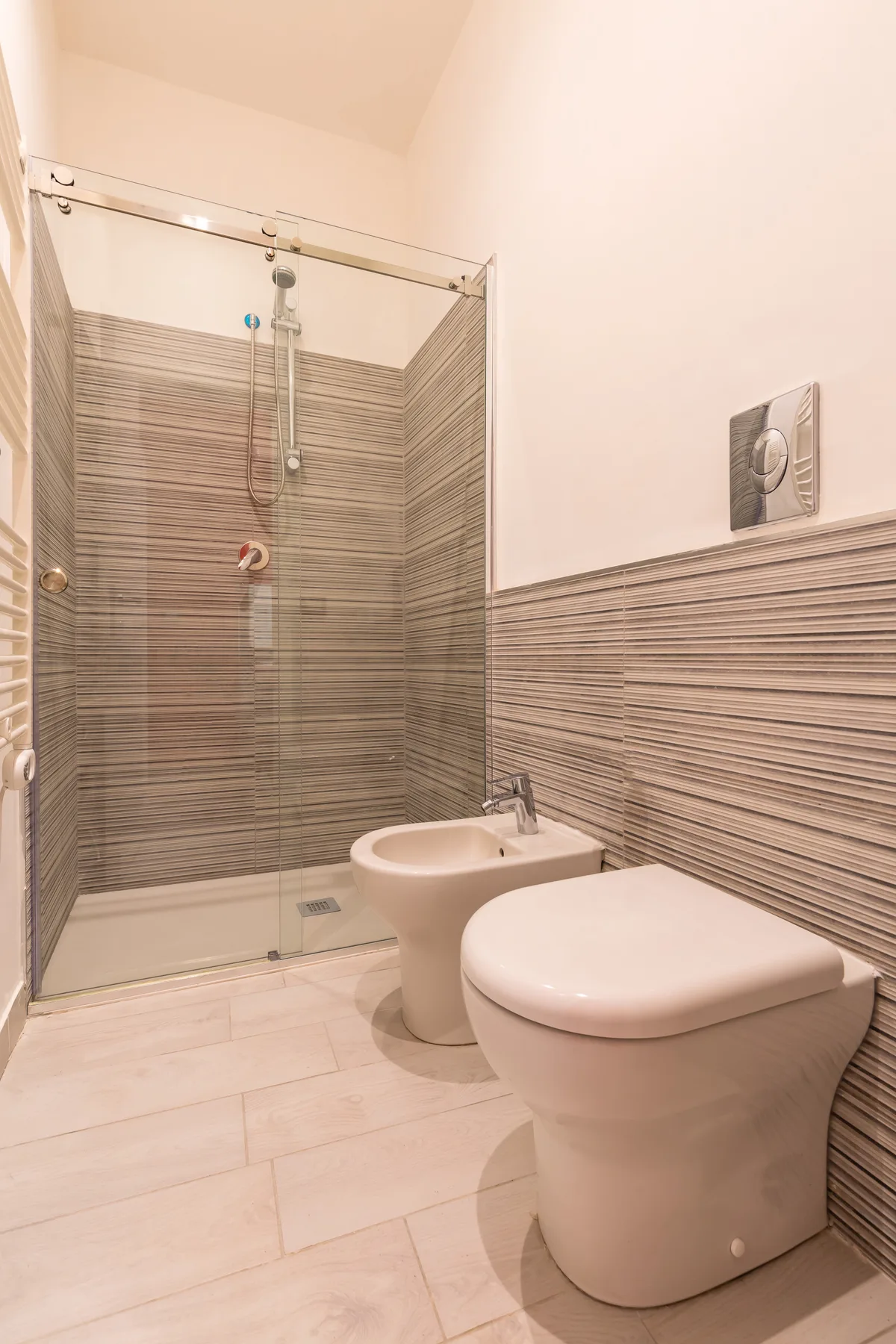 Un baño con ducha de vidrio, lavabo e inodoro.