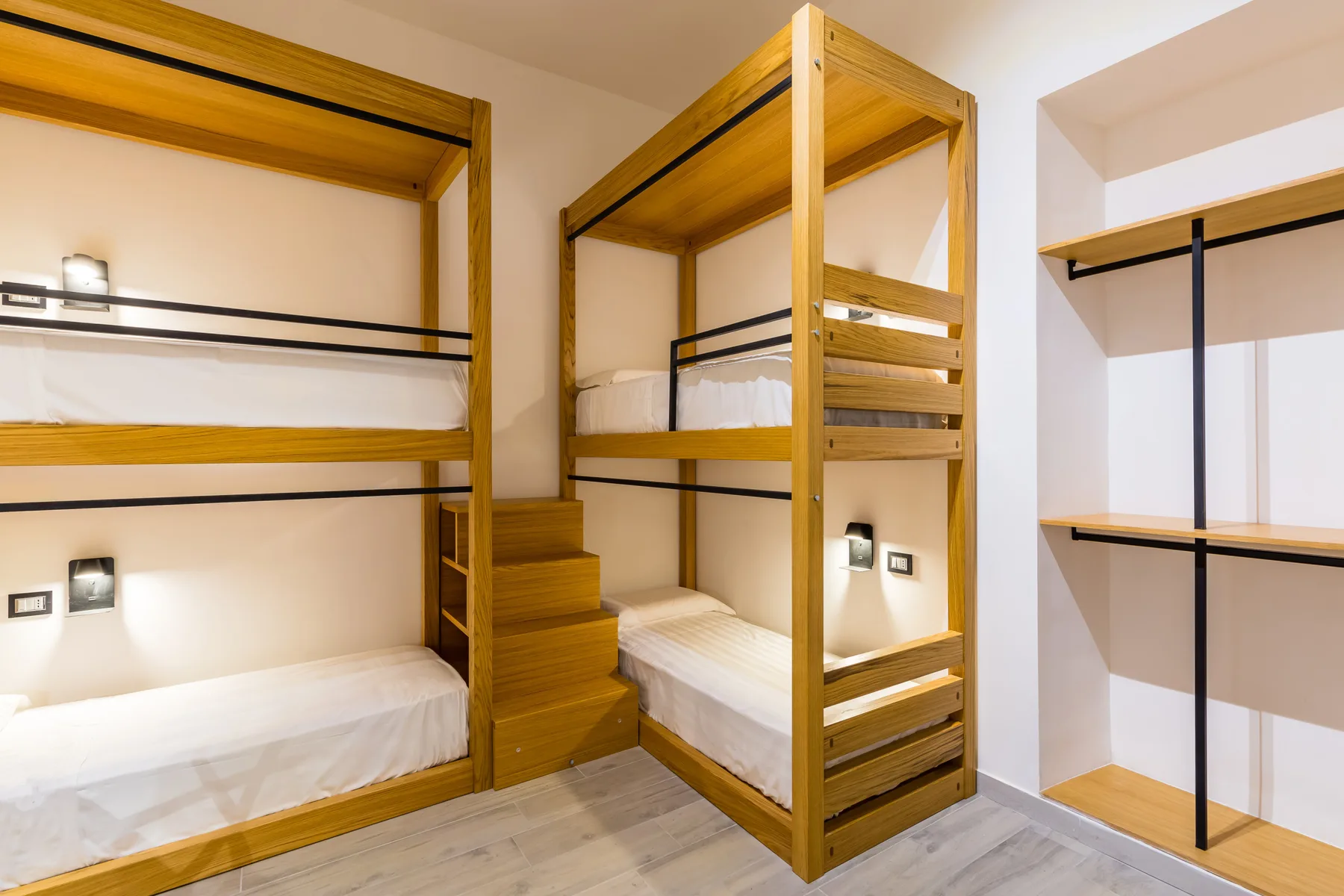 Un dormitorio con literas de madera y escalones integrados.