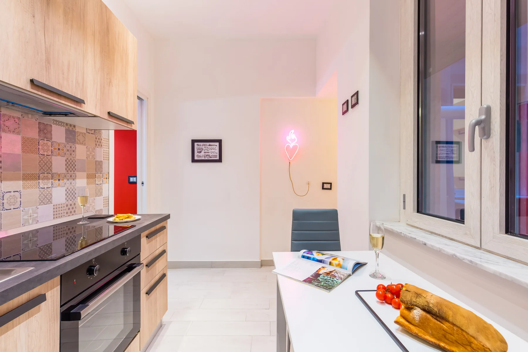 Una cocina compacta con salpicadero de azulejos y una mesa con comida.