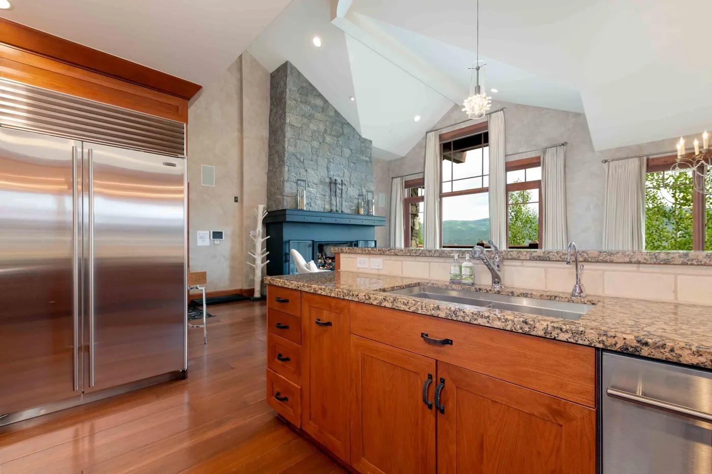 Una cocina amplia con una isla central y un refrigerador de acero inoxidable.