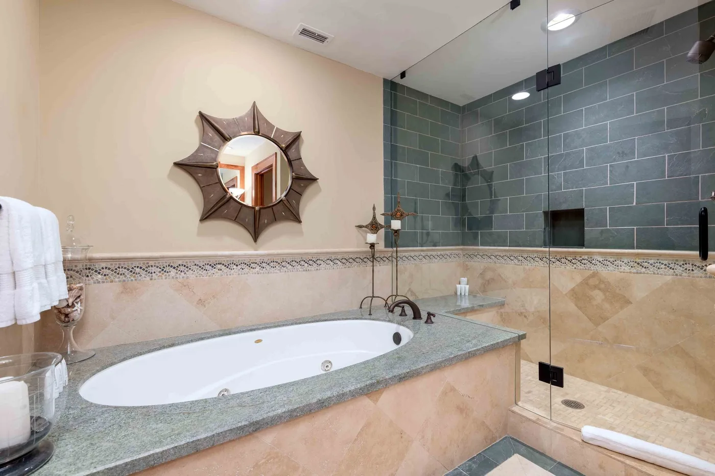 Un baño con una bañera empotrada y una ducha con panel de vidrio.