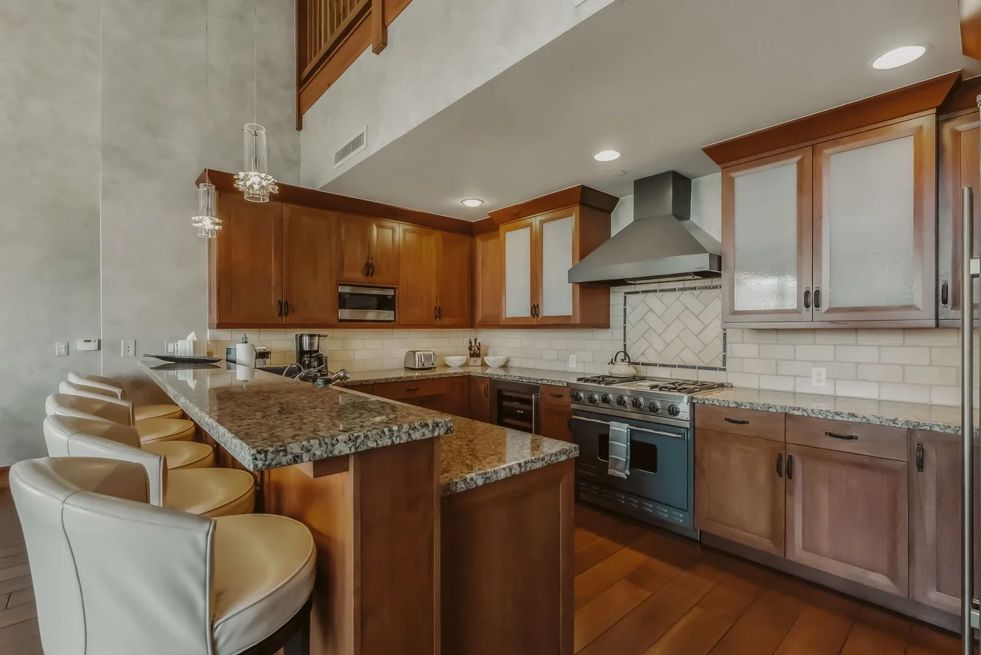 Una cocina amplia con gabinetes de madera, una isla central y electrodomésticos de acero inoxidable.