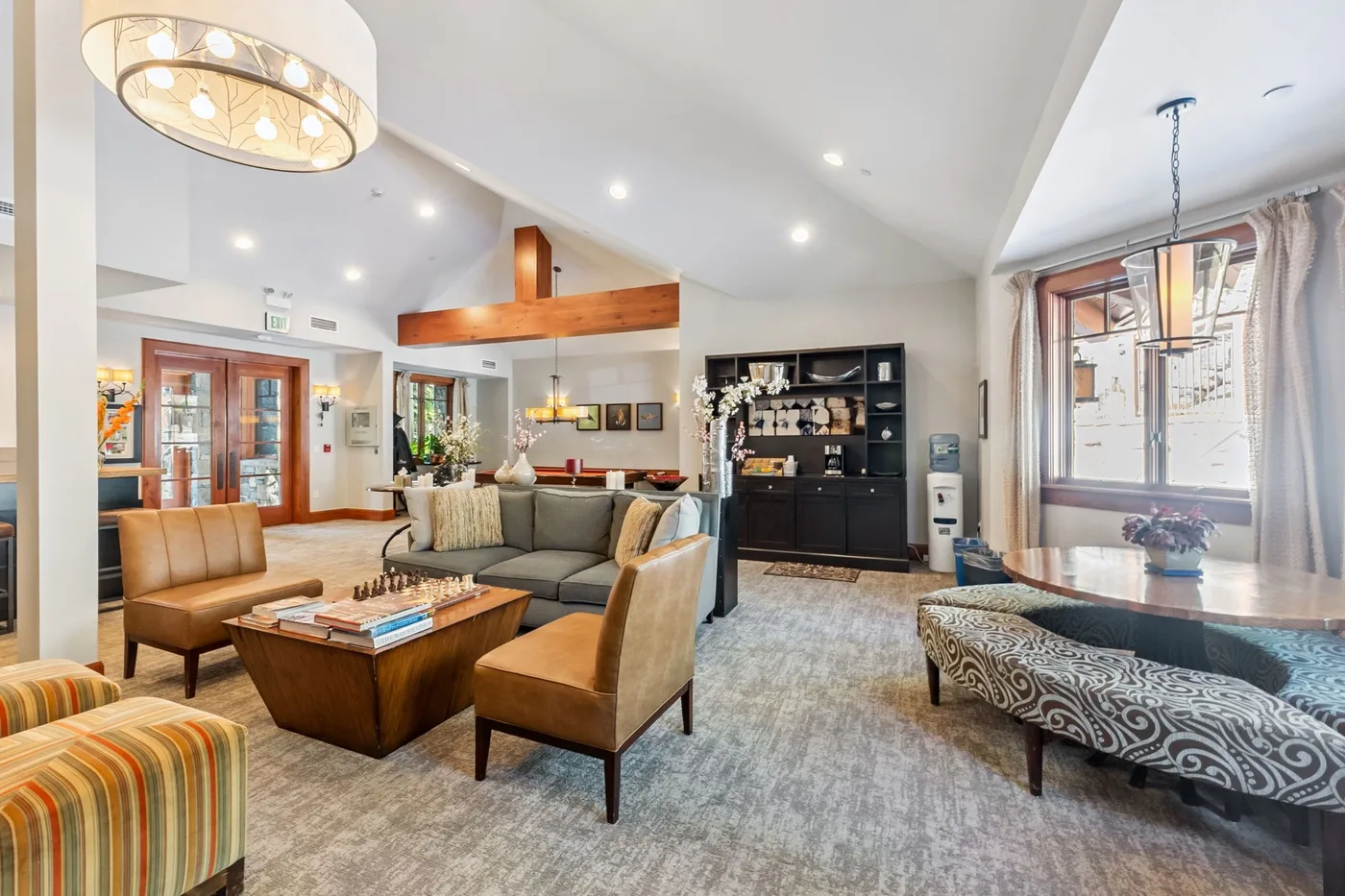Una sala luminosa con asientos, una mesa de centro y una ventana grande.