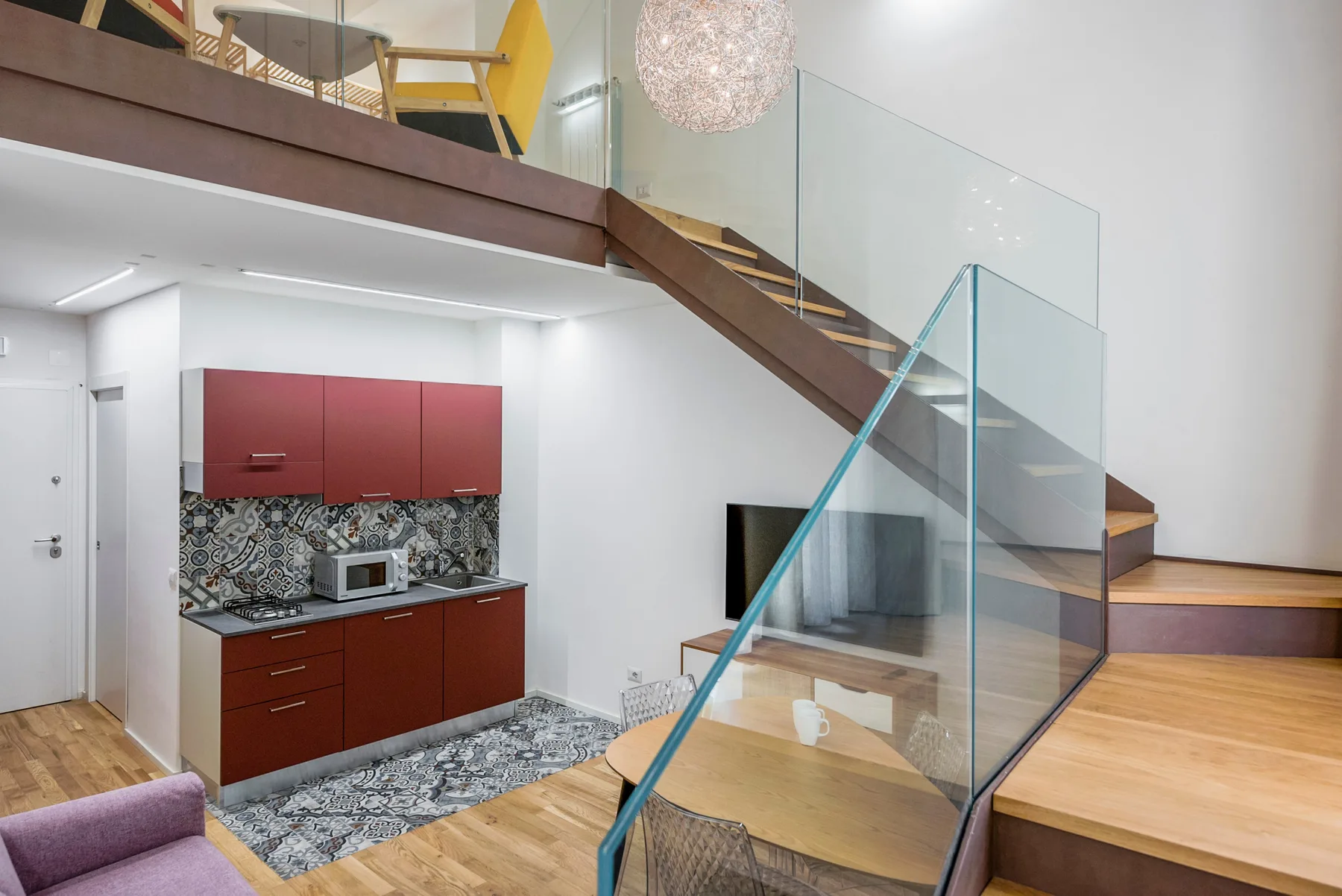 Un interior moderno con una cocina compacta debajo de una escalera.
