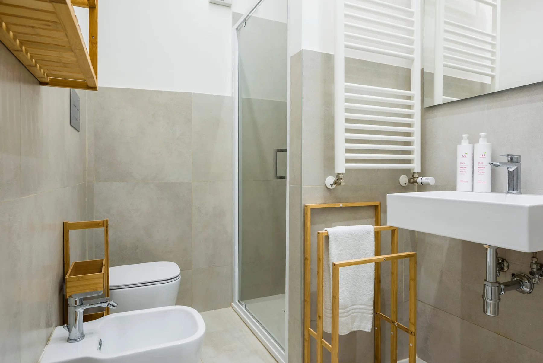 A modern bathroom with a shower, toilet, and wall-mounted sink.