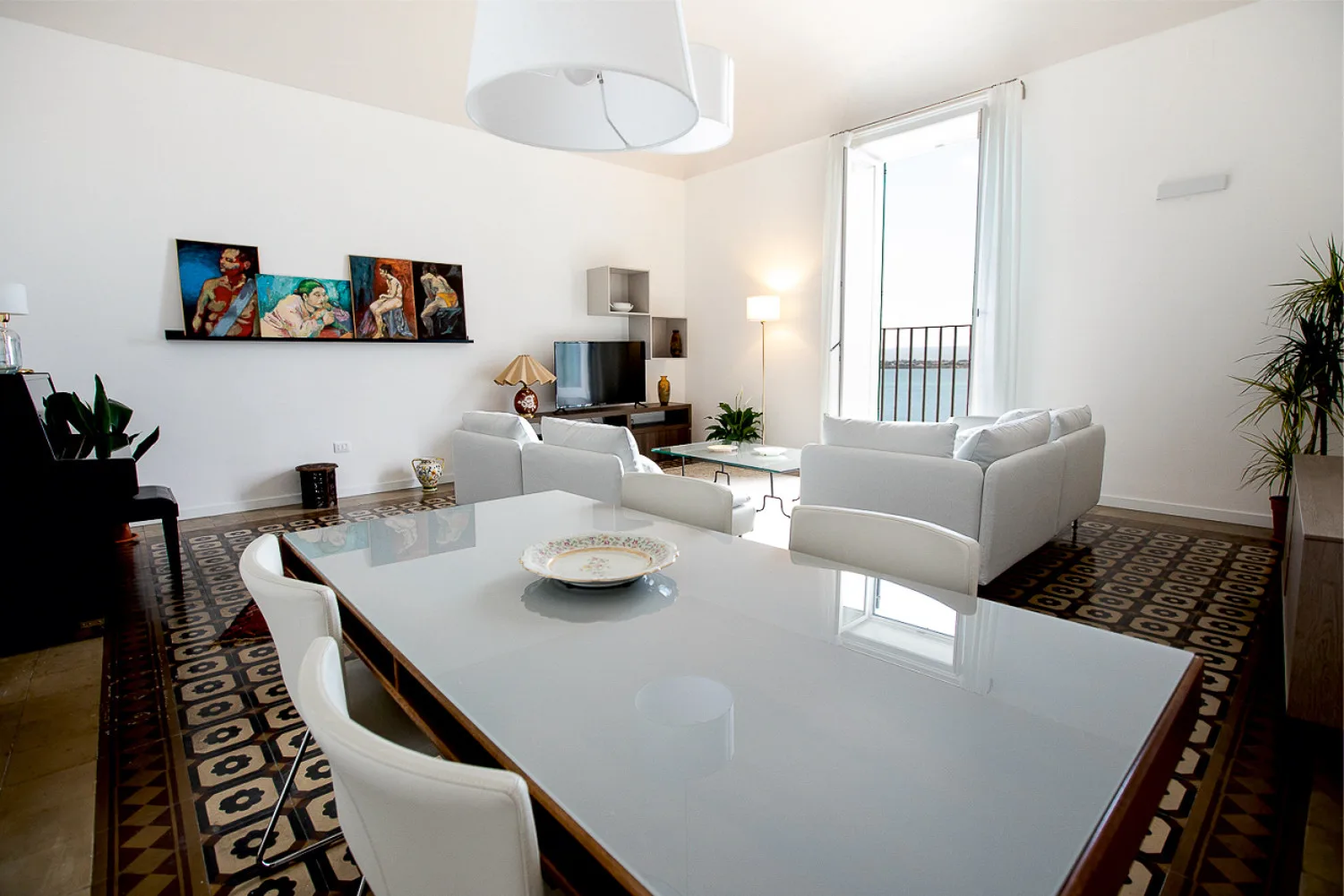 Una sala luminosa con asientos, una mesa grande y ventanas altas.