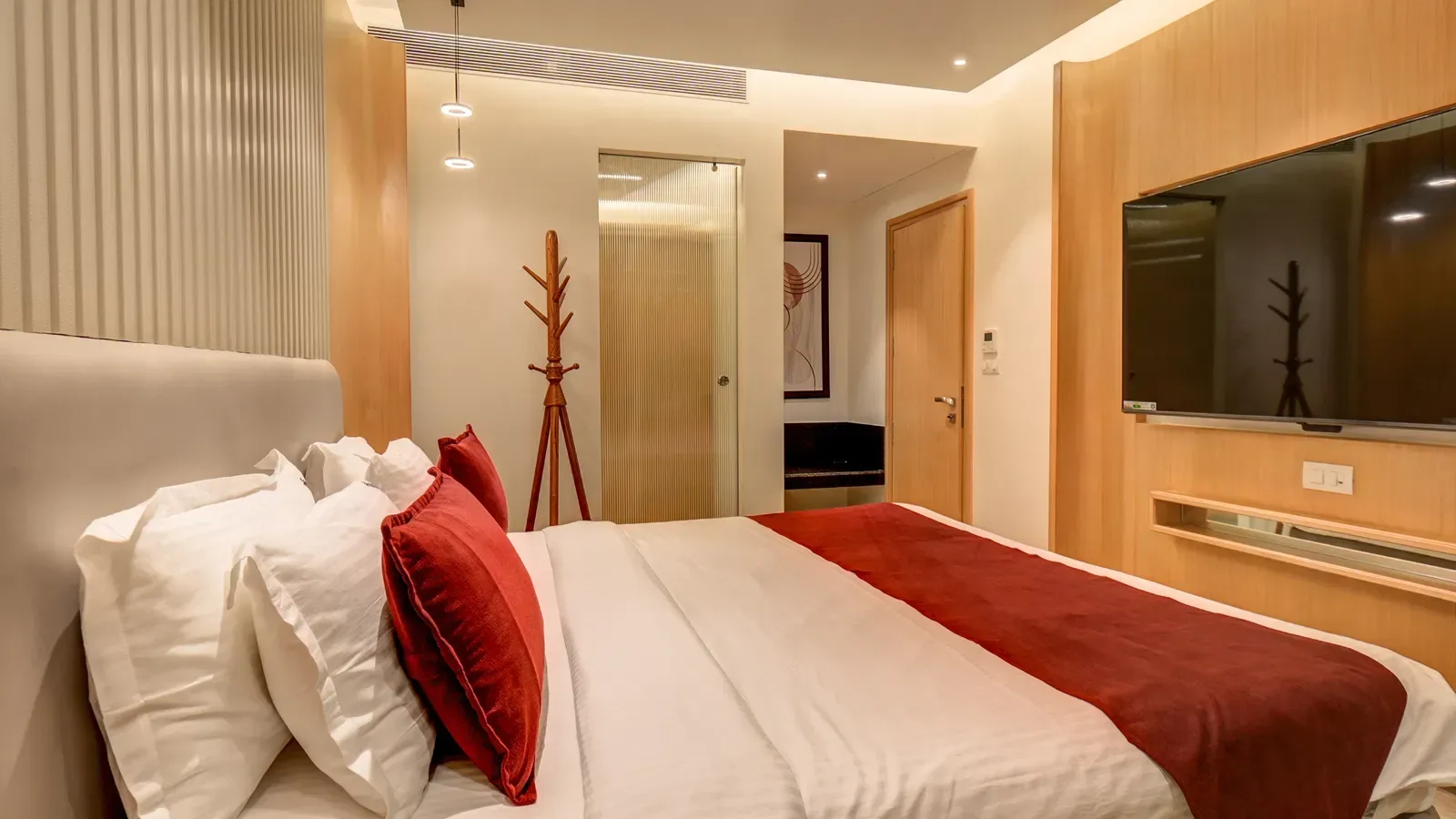 Dormitorio con cama y televisor montado en la pared