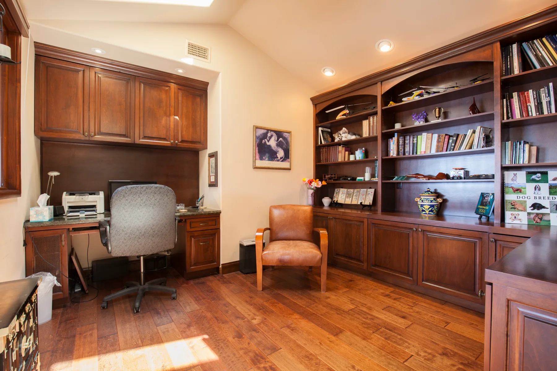 A home office with built-in wooden shelving and a desk.