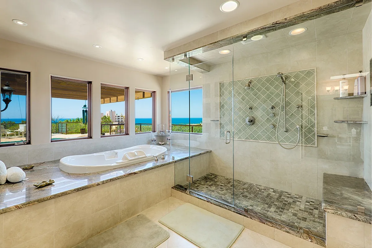 A spacious bathroom with a built-in tub and glass-enclosed shower.