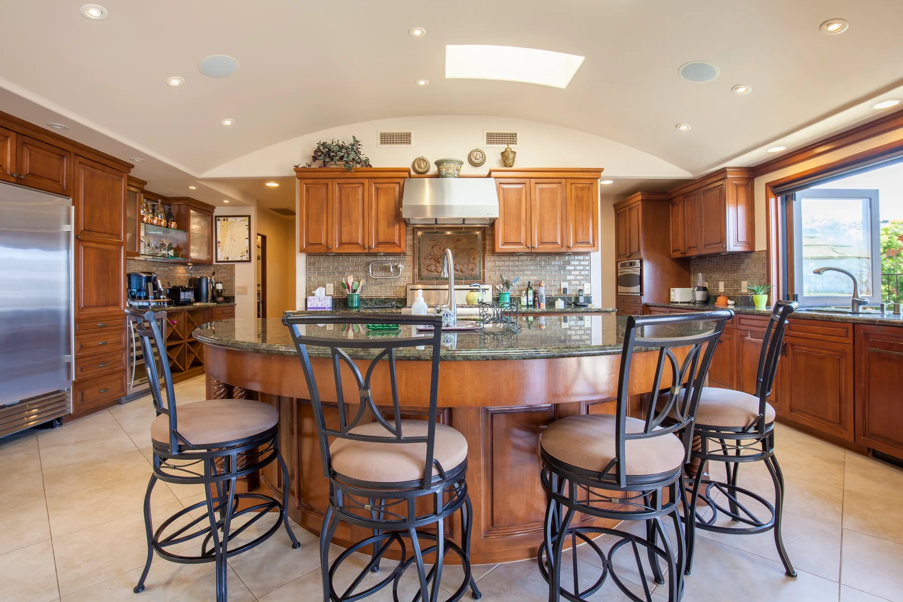 A spacious kitchen with a curved island and bar seating.
