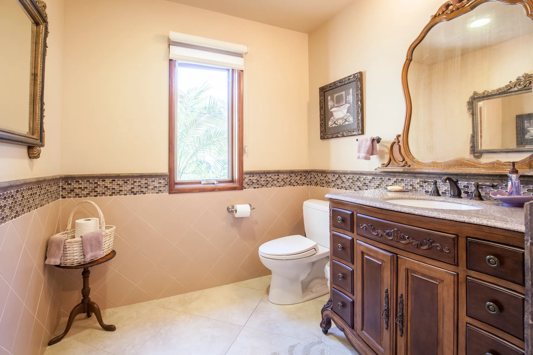 A bathroom with a toilet, sink, and a window.