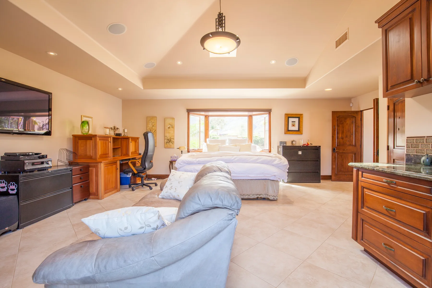 A spacious bedroom with a bed, a desk, and seating.
