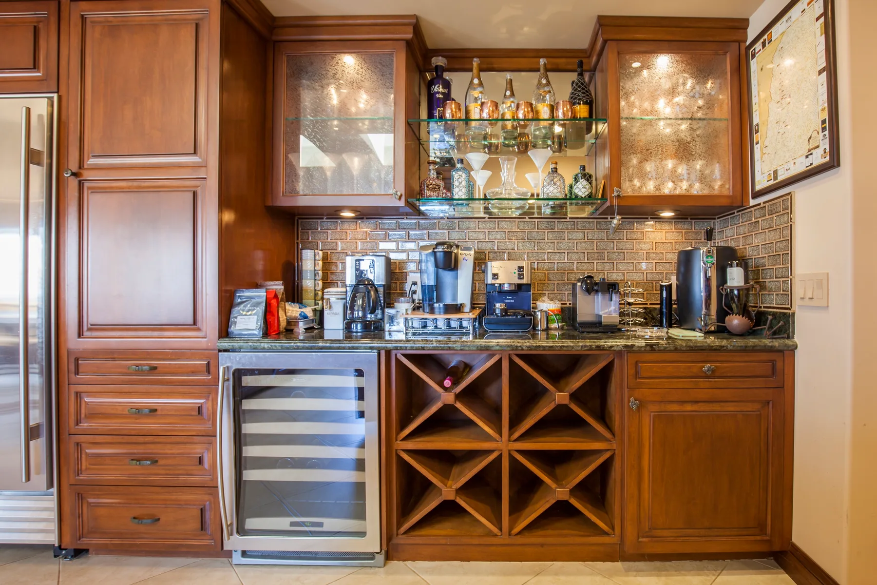 A built-in bar area with glass-front cabinets, countertop appliances, and a wine rack.