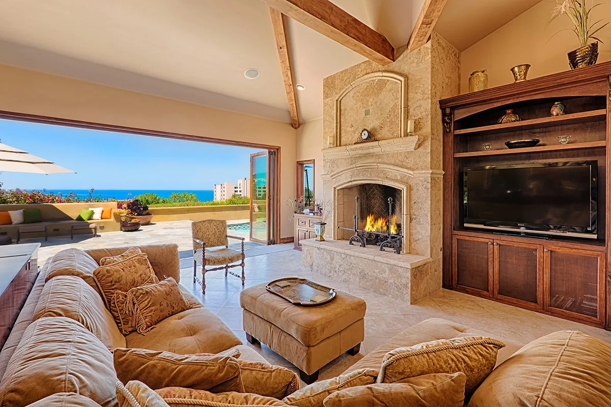 A living room with seating, a fireplace, and an open view toward the terrace.