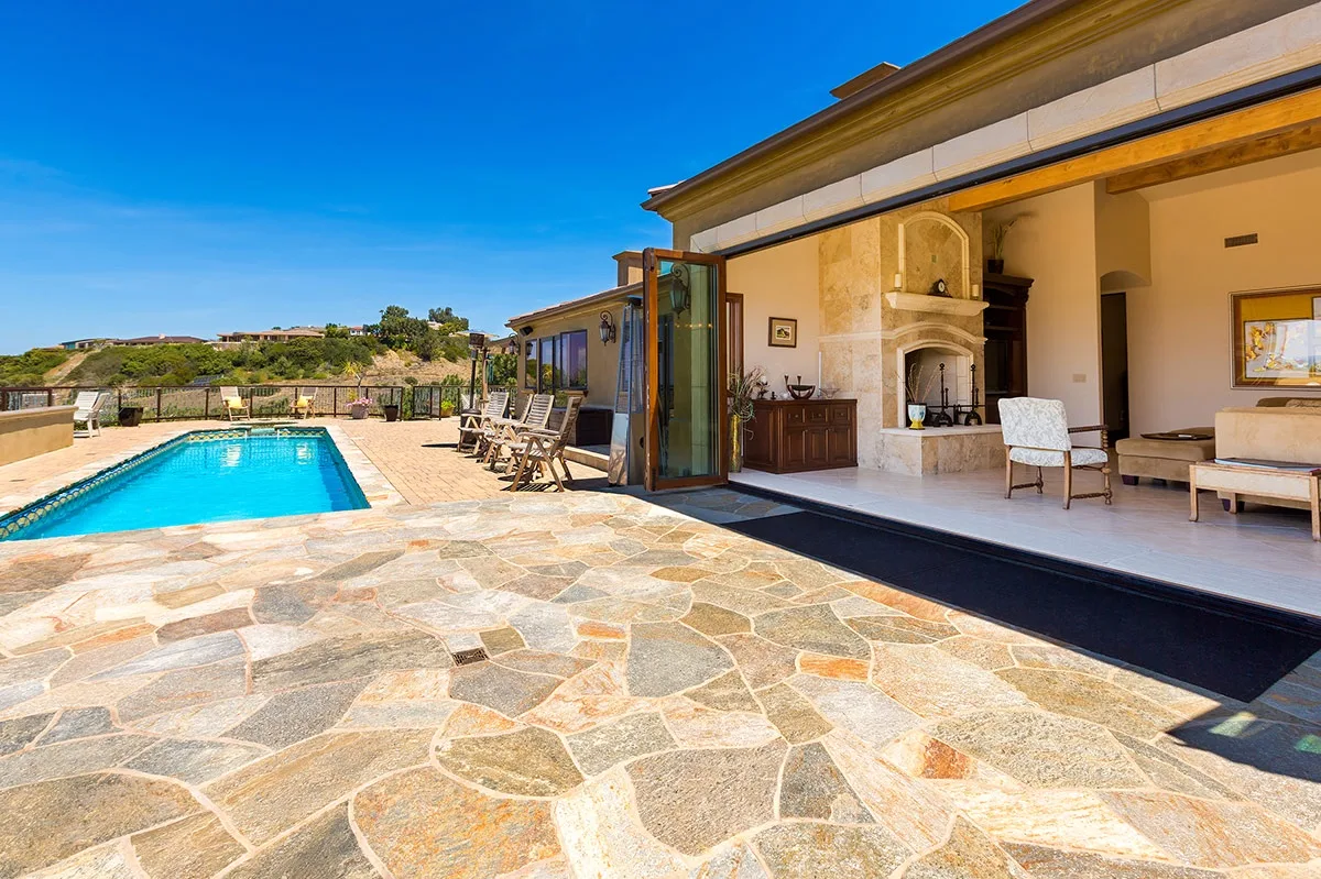 A patio with a swimming pool beside an open living area.