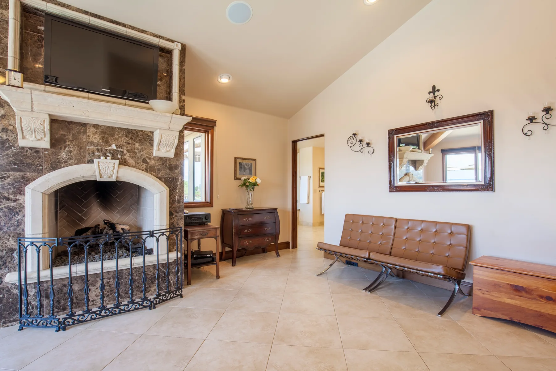 A living room with a fireplace, wall mirror, and bench seating.