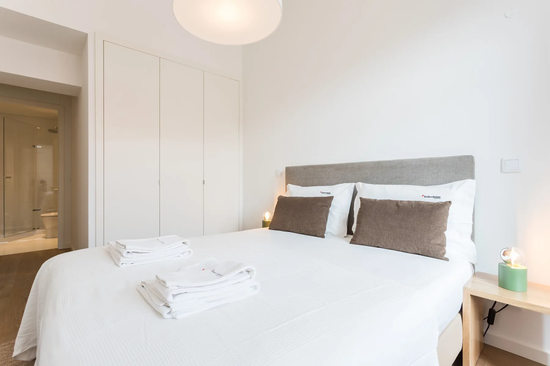 Un dormitorio con una cama bien hecha y toallas dobladas.
