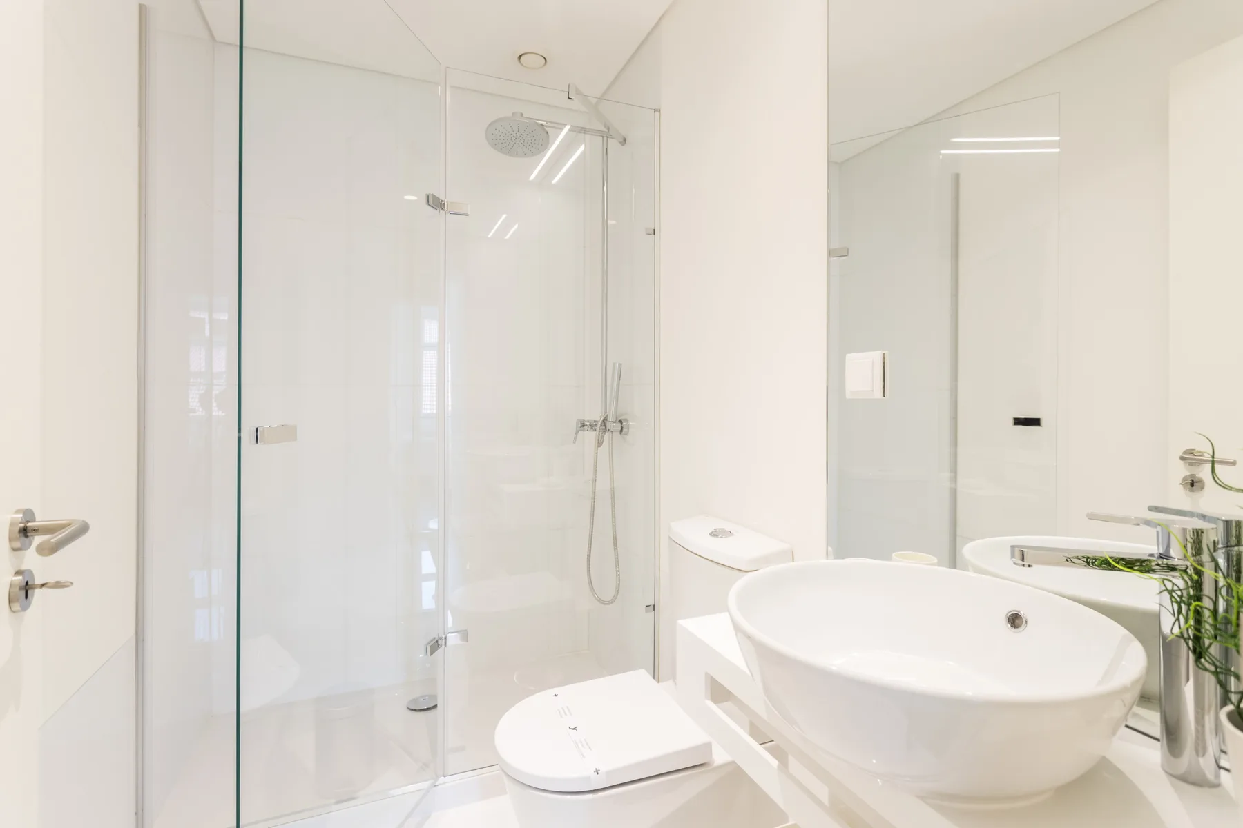 Un baño luminoso con ducha de vidrio, inodoro y lavabo amplio.