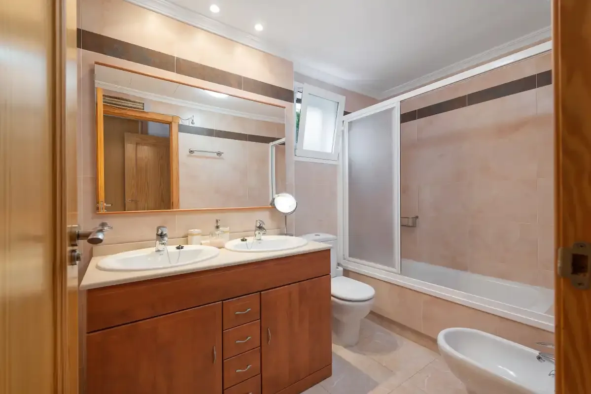 A bathroom with a double sink vanity and a bathtub.