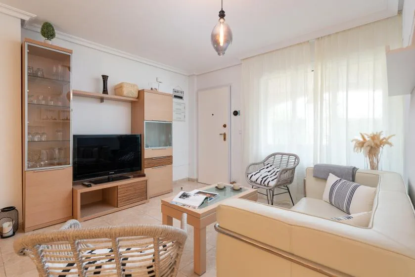 A bright living room with seating, a television, and a coffee table.