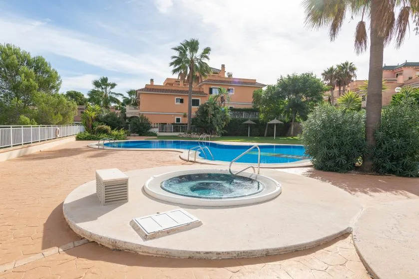 An outdoor pool area with a round spa in the foreground.