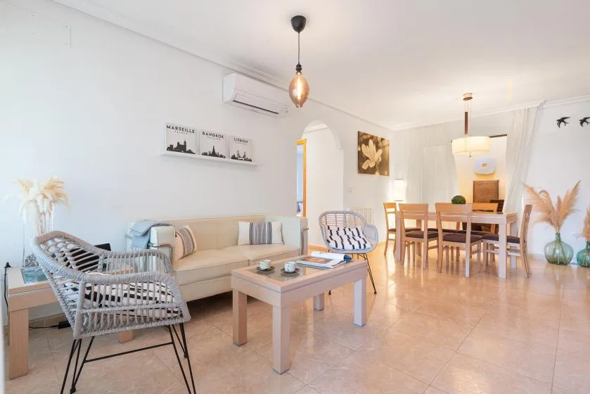 A bright living and dining area with seating, a coffee table, and a dining table.