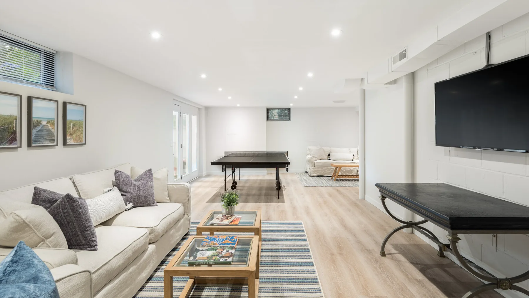 Una sala luminosa con asientos, una mesa de centro y un televisor.