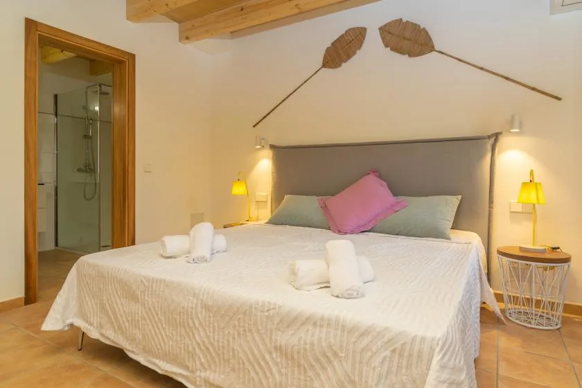 Un dormitorio con una cama grande, almohadas y lámparas de noche.