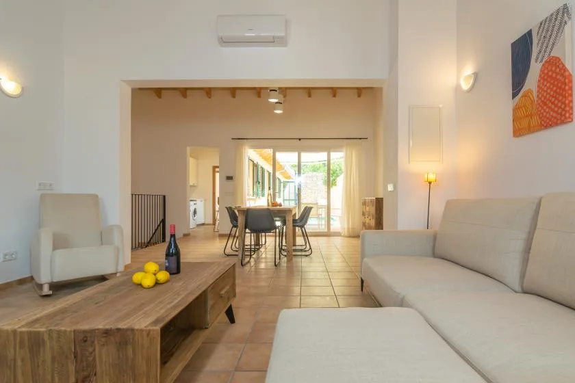 Una sala luminosa con asientos, una mesa baja de madera y un comedor.