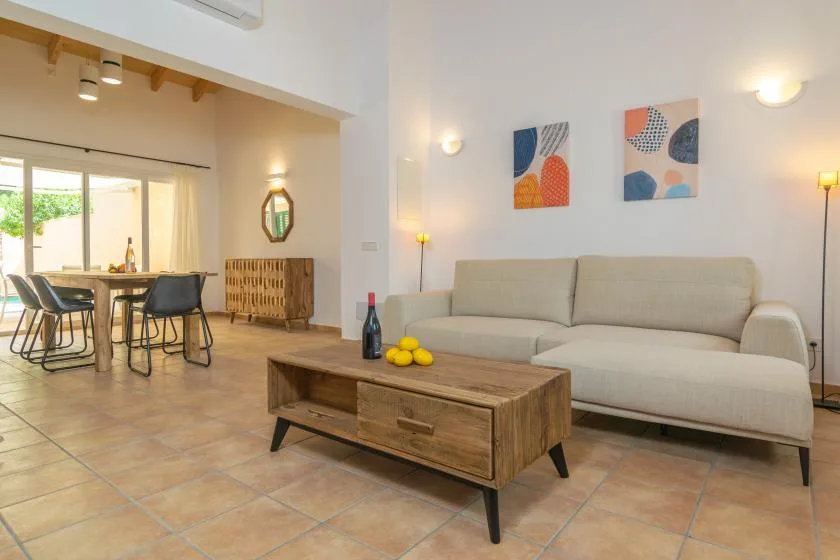Una luminosa sala de estar y comedor con sofá, mesa de centro y mesa de comedor.