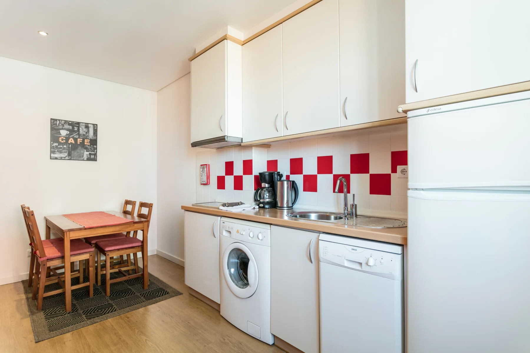 Cocina y comedor con una mesa junto a la encimera.
