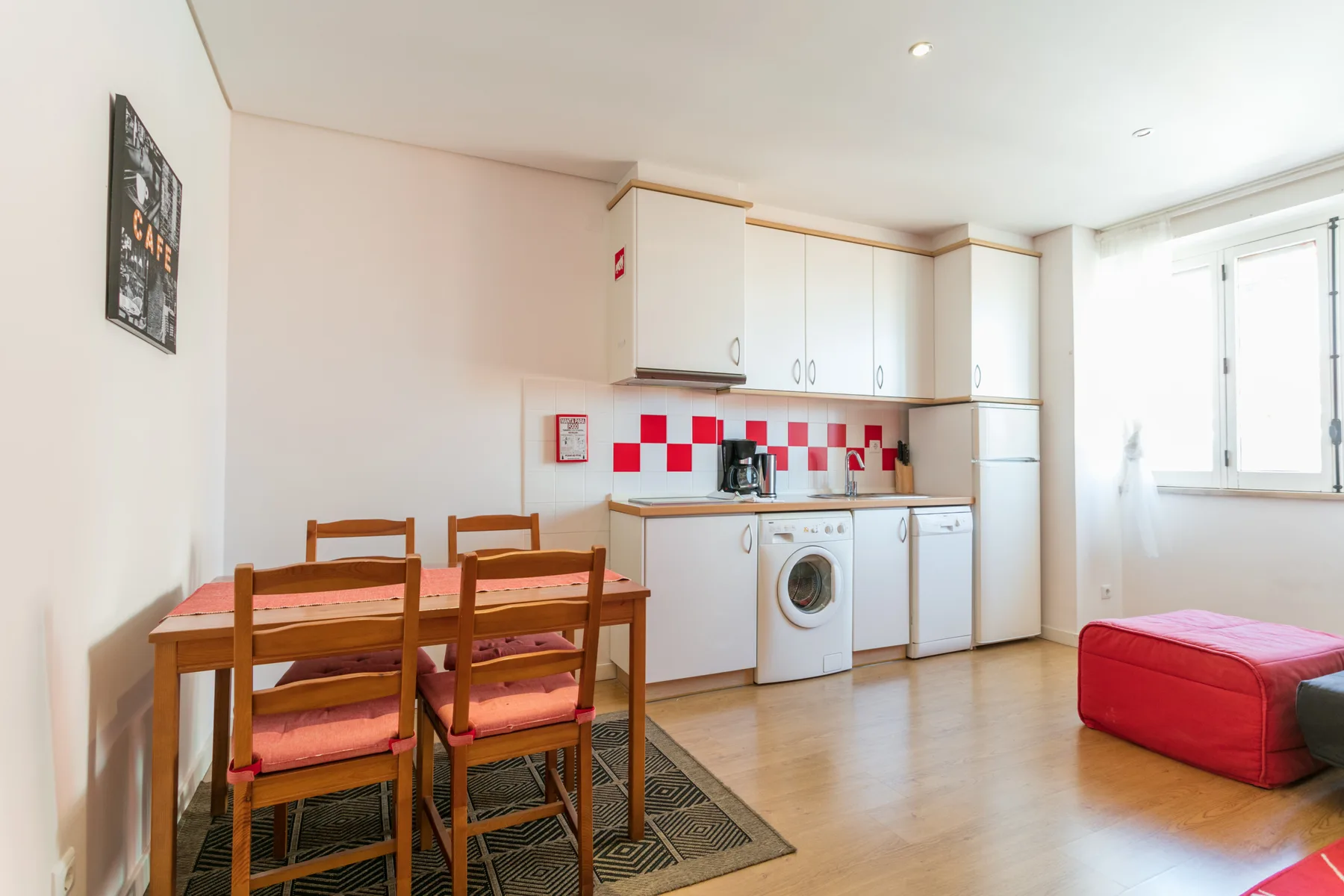 Una cocina y comedor luminosos con una mesa junto a los armarios.