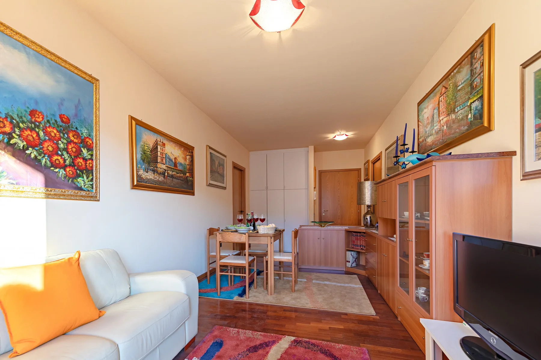 Una sala de estar con asientos, una mesa de comedor y un televisor.