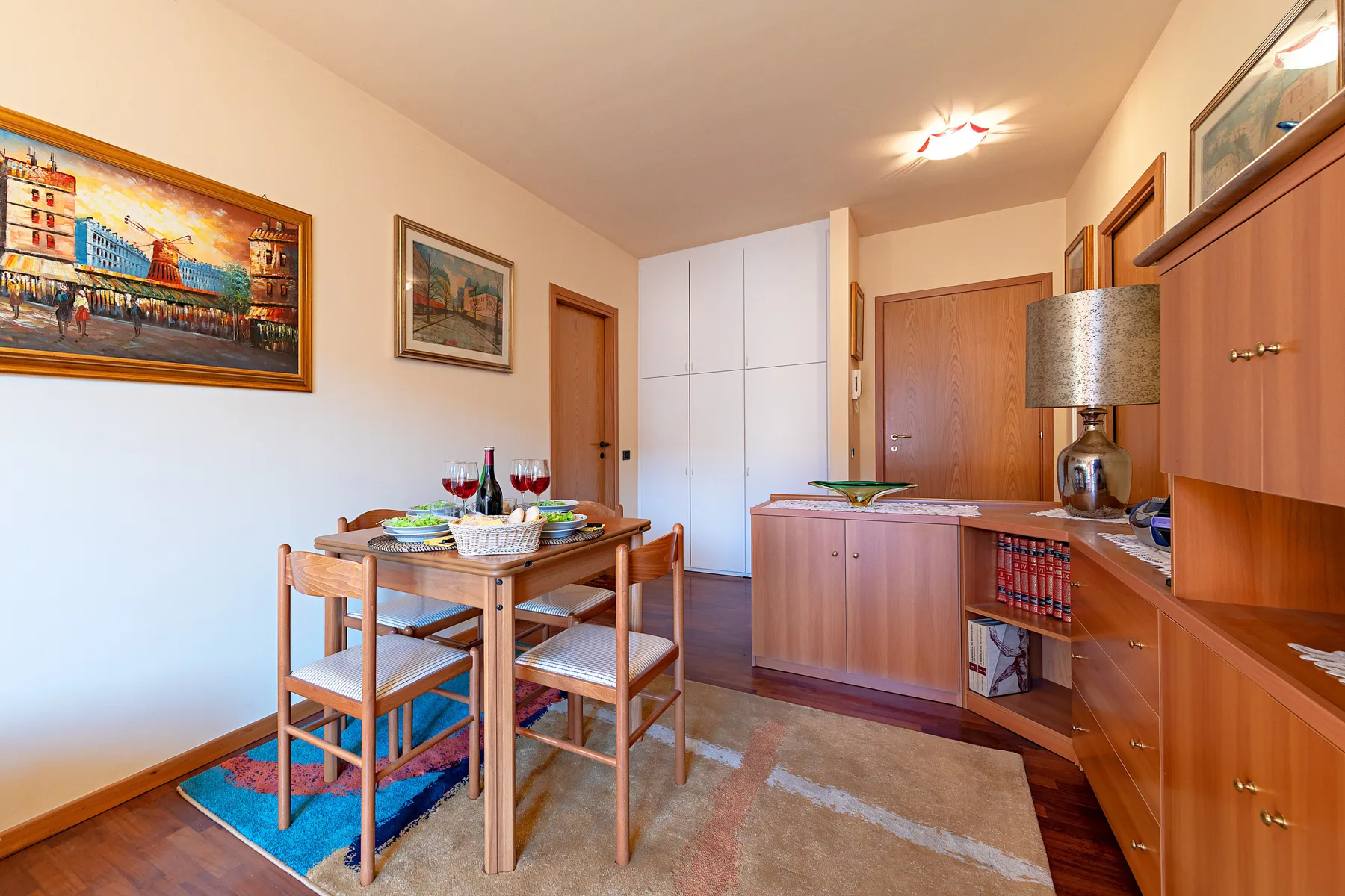 Un comedor con una mesa de madera y armarios empotrados.
