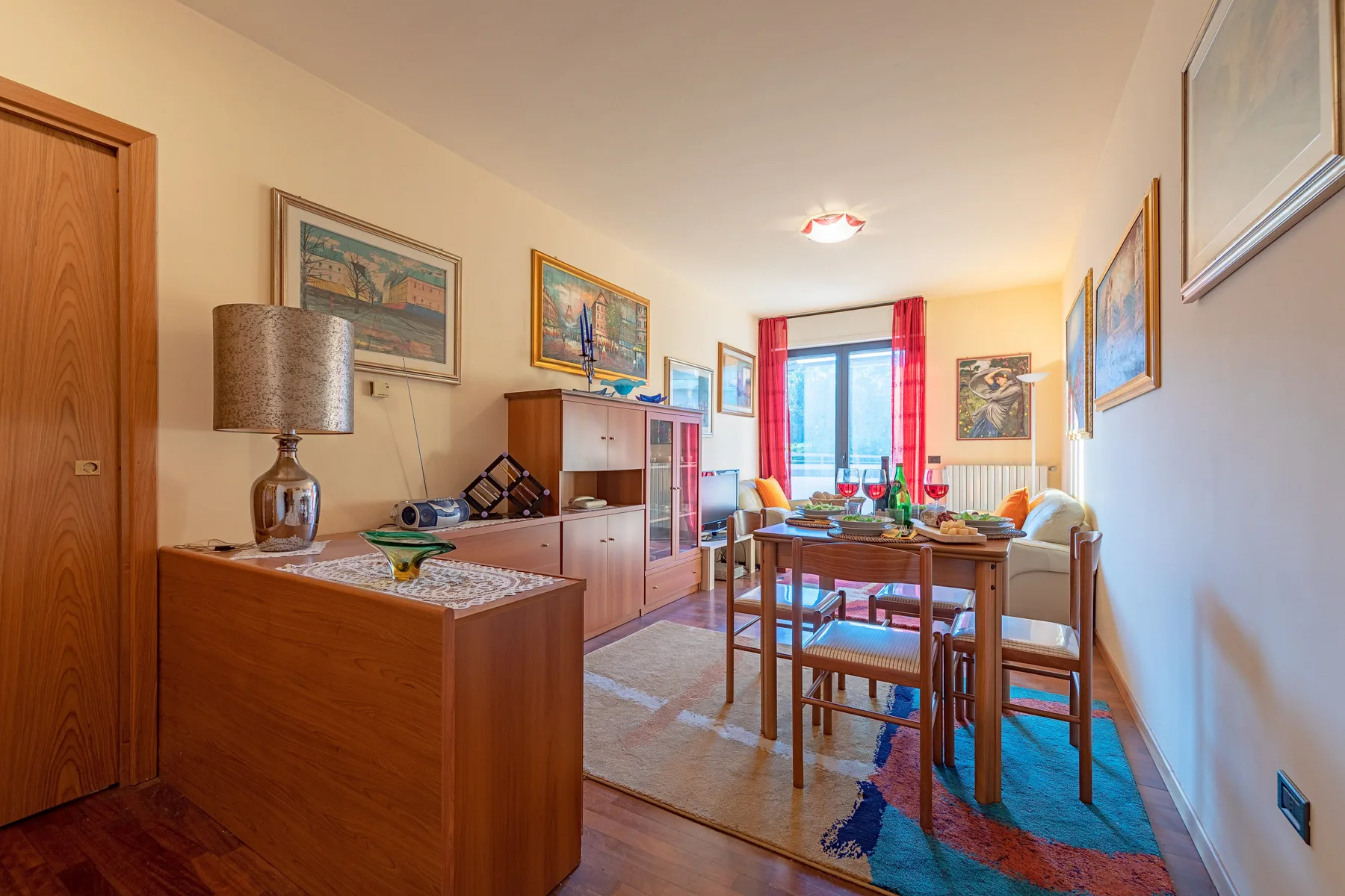Un comedor con una mesa de madera y sillas junto a una ventana luminosa.