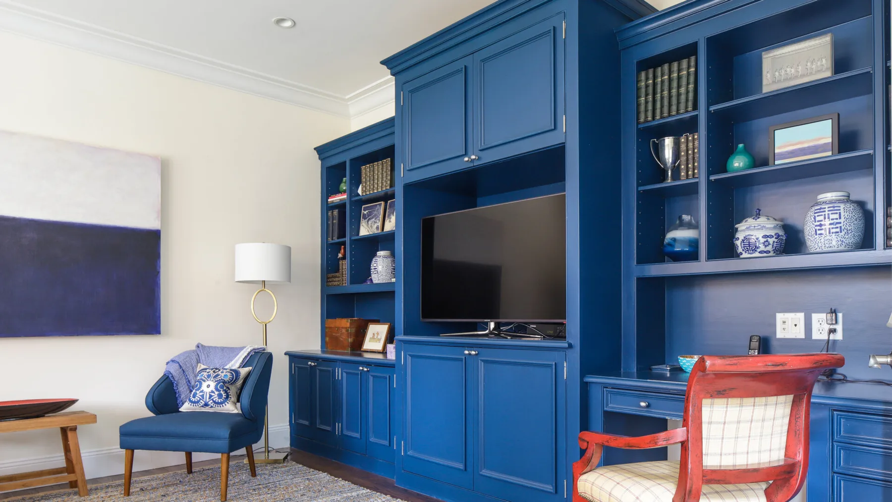 A living room with built-in blue shelving and a television.