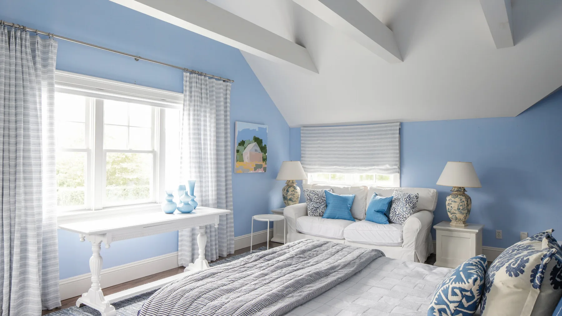 A bright living room with blue walls, a sofa, and a large window.