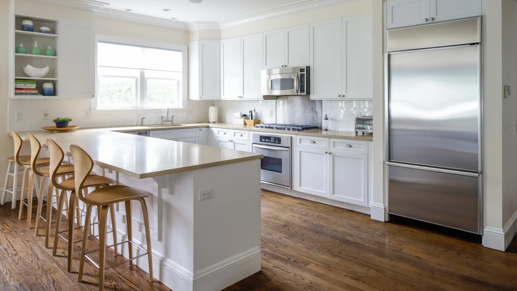 A bright kitchen with white cabinets, a large island, and stainless steel appliances.