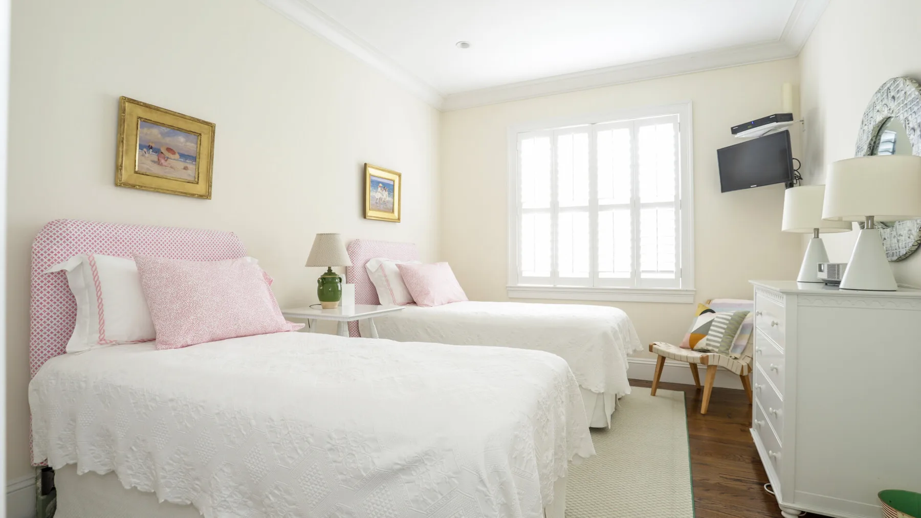 A bright bedroom with two beds and a large window.
